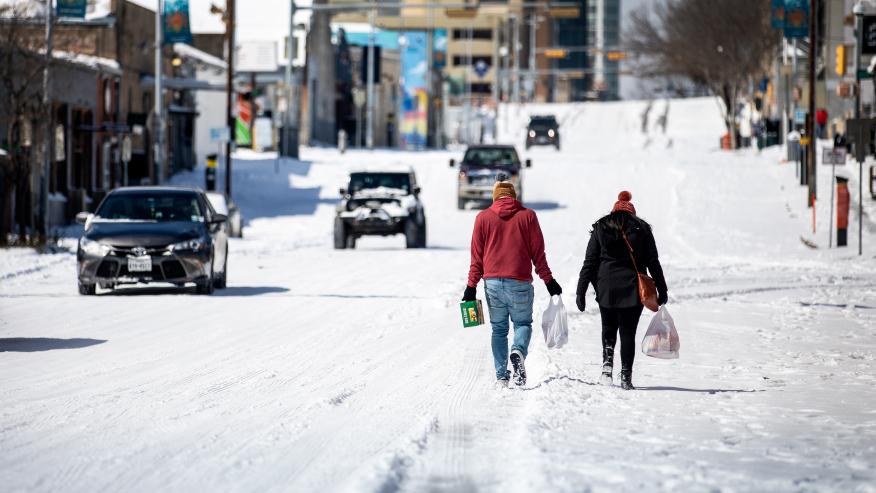 AUSTIN, TX - FEBRUARY 15: People carry groceries from a local gas station on February 15, 2021 in Austin, Texas. Winter storm Uri has brought historic cold weather to Texas, causing traffic delays and power outages, and storms have swept across 26 states with a mix of freezing temperatures and precipitation. (Photo by Montinique Monroe/Getty Images)