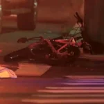 Police lights near a Staten Island roadway after a fatal collision involving a bicyclist and an ambulance