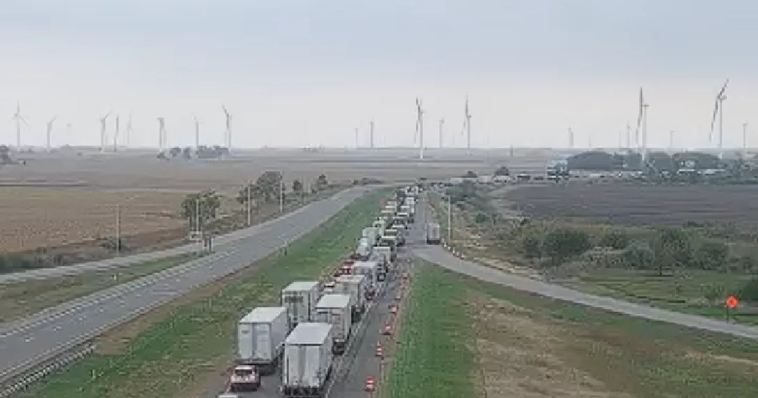 Emergency response crews at a closed Interstate 65 crash scene with traffic backed up nearby