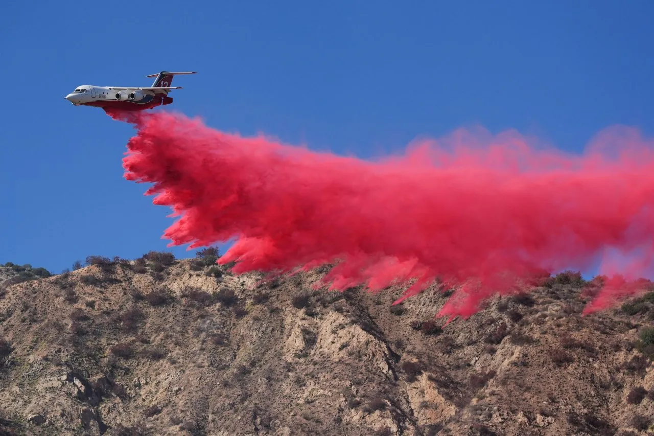 Smoke rises over Southern California hills as firefighters respond to brush fires during strong winds