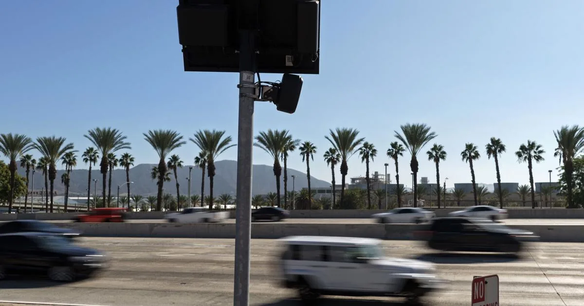 Police vehicle and license plate reader camera mounted near a roadway