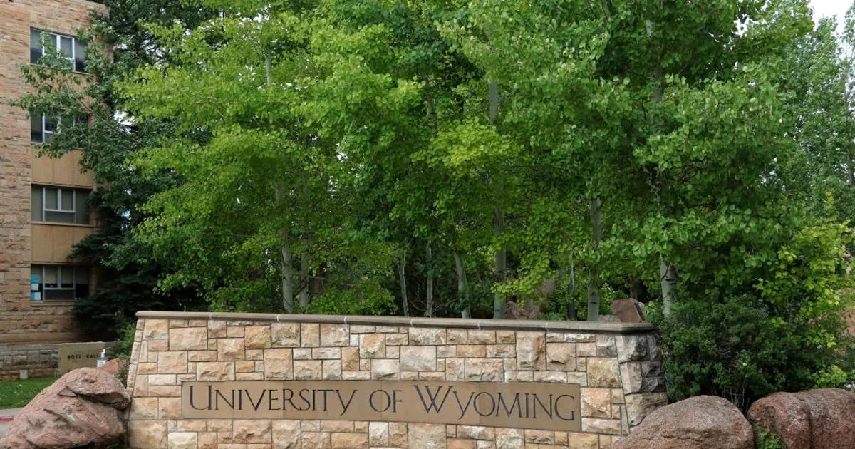 University of Wyoming campus sign with an inset of airport police arresting a woman